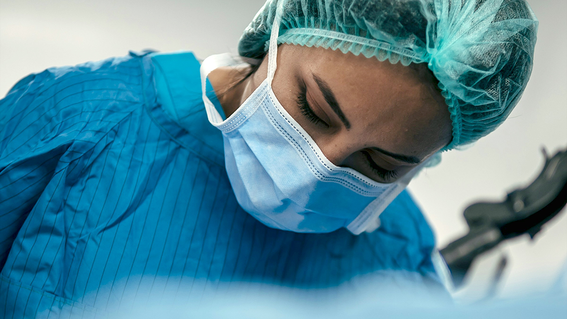 OP-Personal mit Schutzkleidung während eines chirurgischen Eingriffs